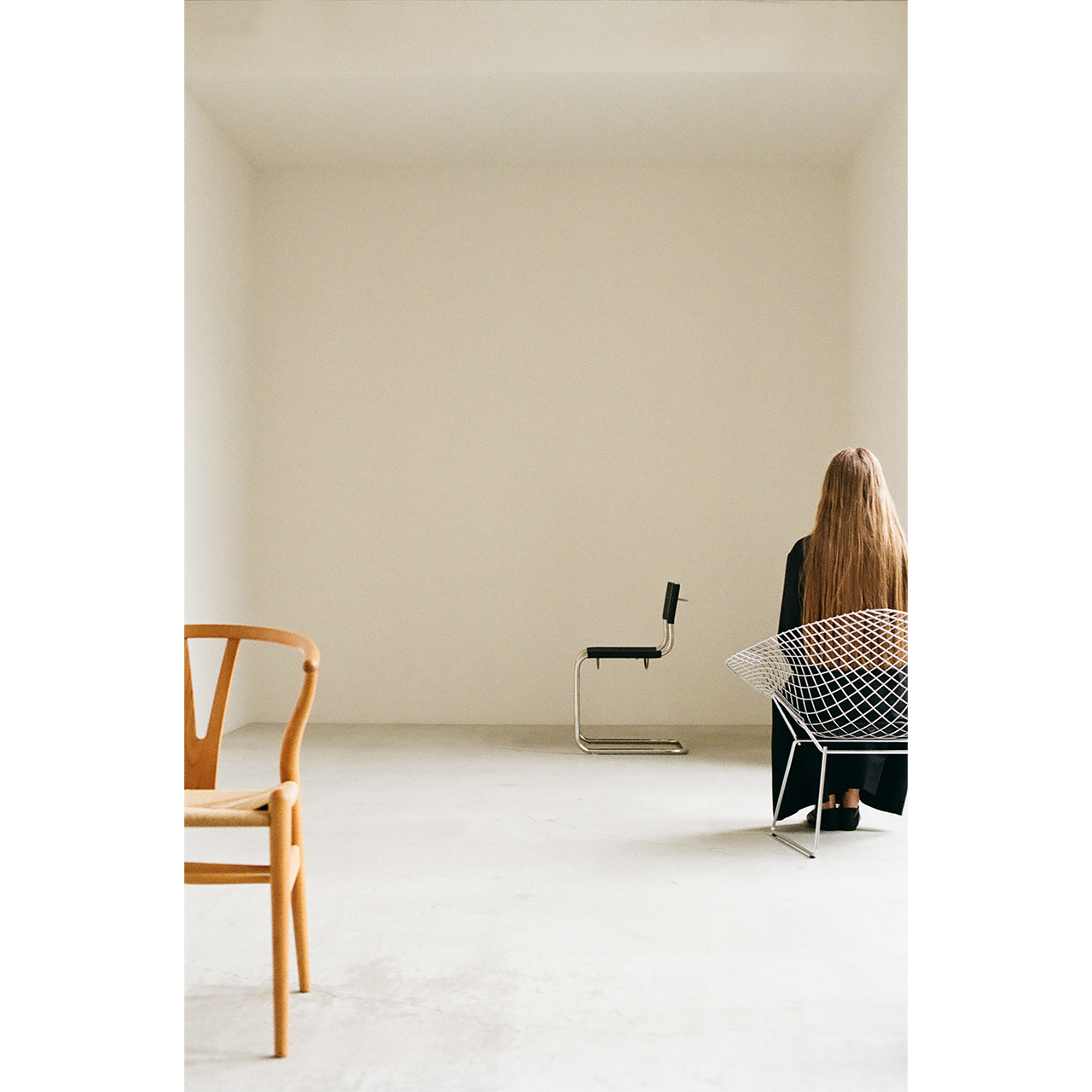 Mochi 2026 Autumn Winter image look 11 featuring the back view of a model seated in a wire chair.