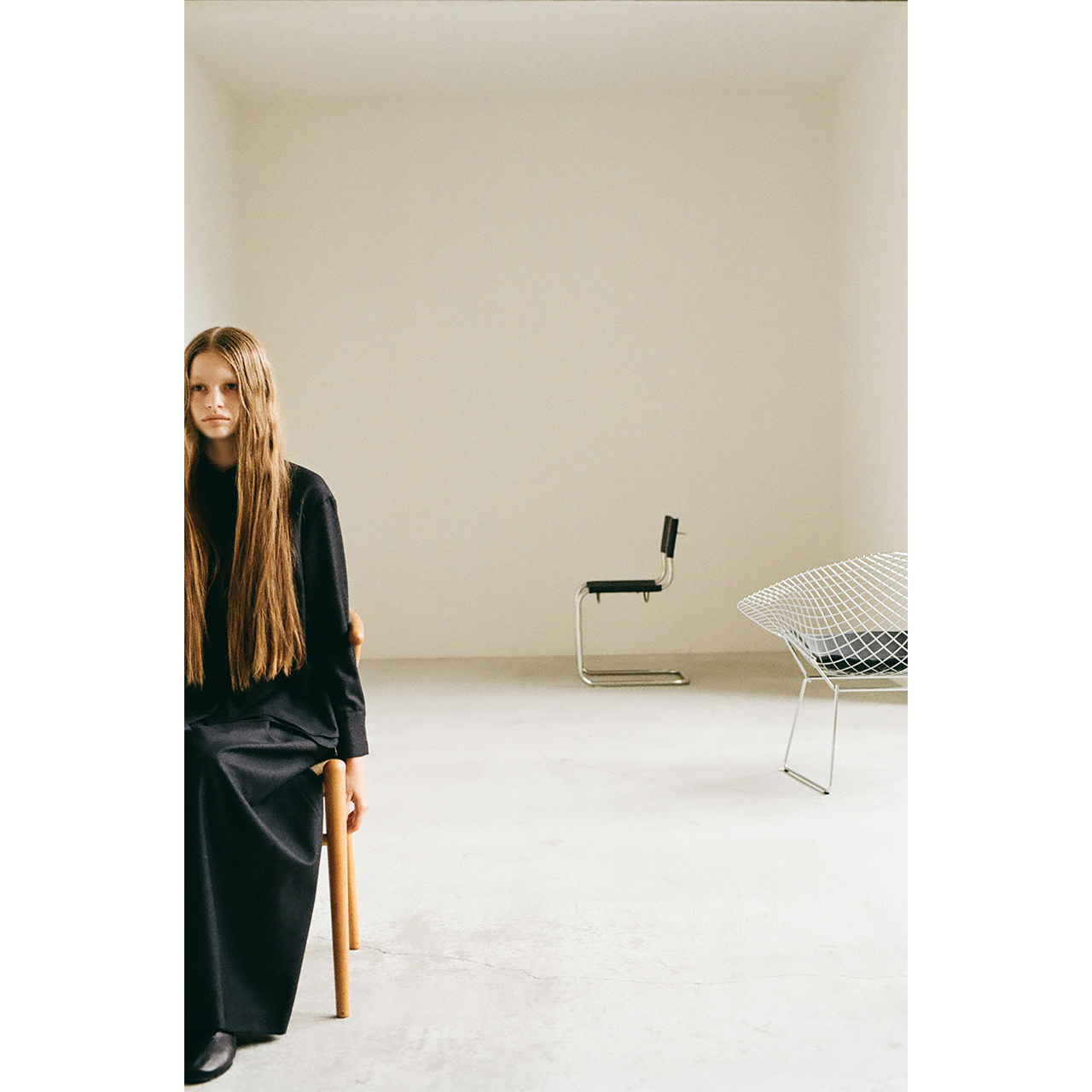 Mochi 2026 Autumn Winter image look 12 featuring a portrait of a model seated on a wooden chair.
