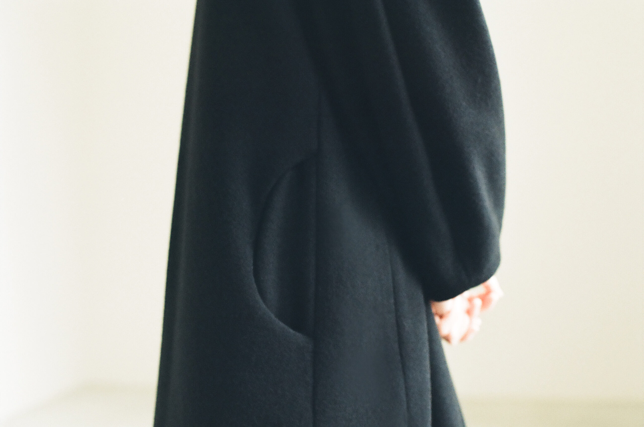Pocket detail of a black wool coat in the Mochi 2026 Autumn Winter image look.