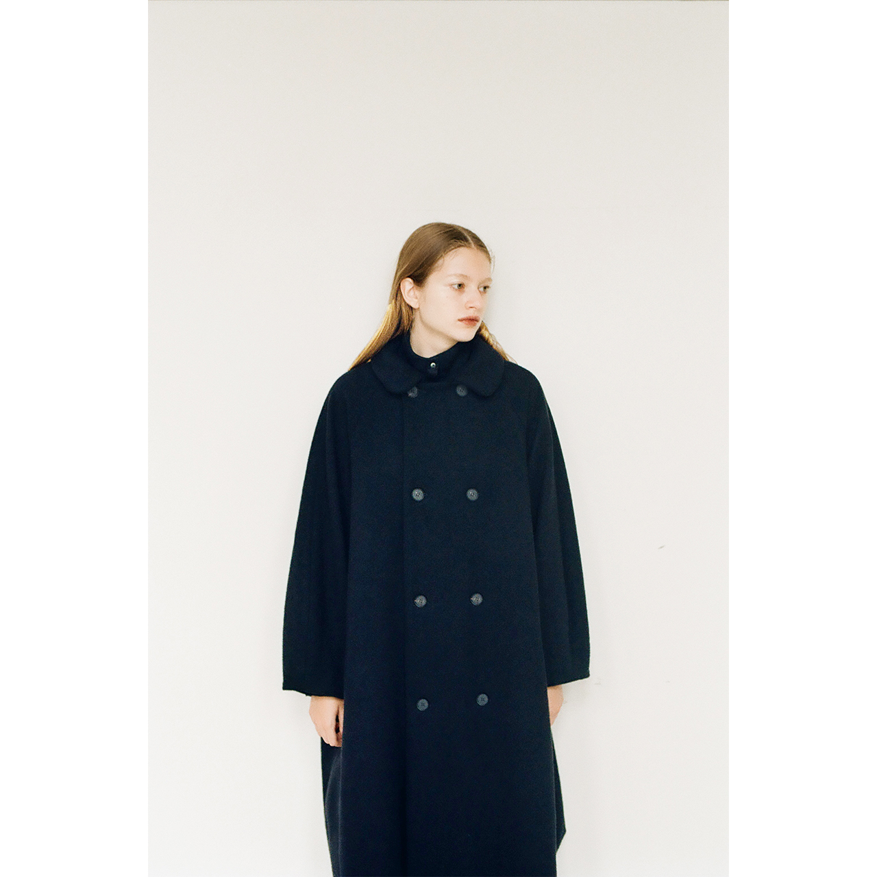 Model wearing a black double-breasted coat in the Mochi 2026 Autumn Winter image look.