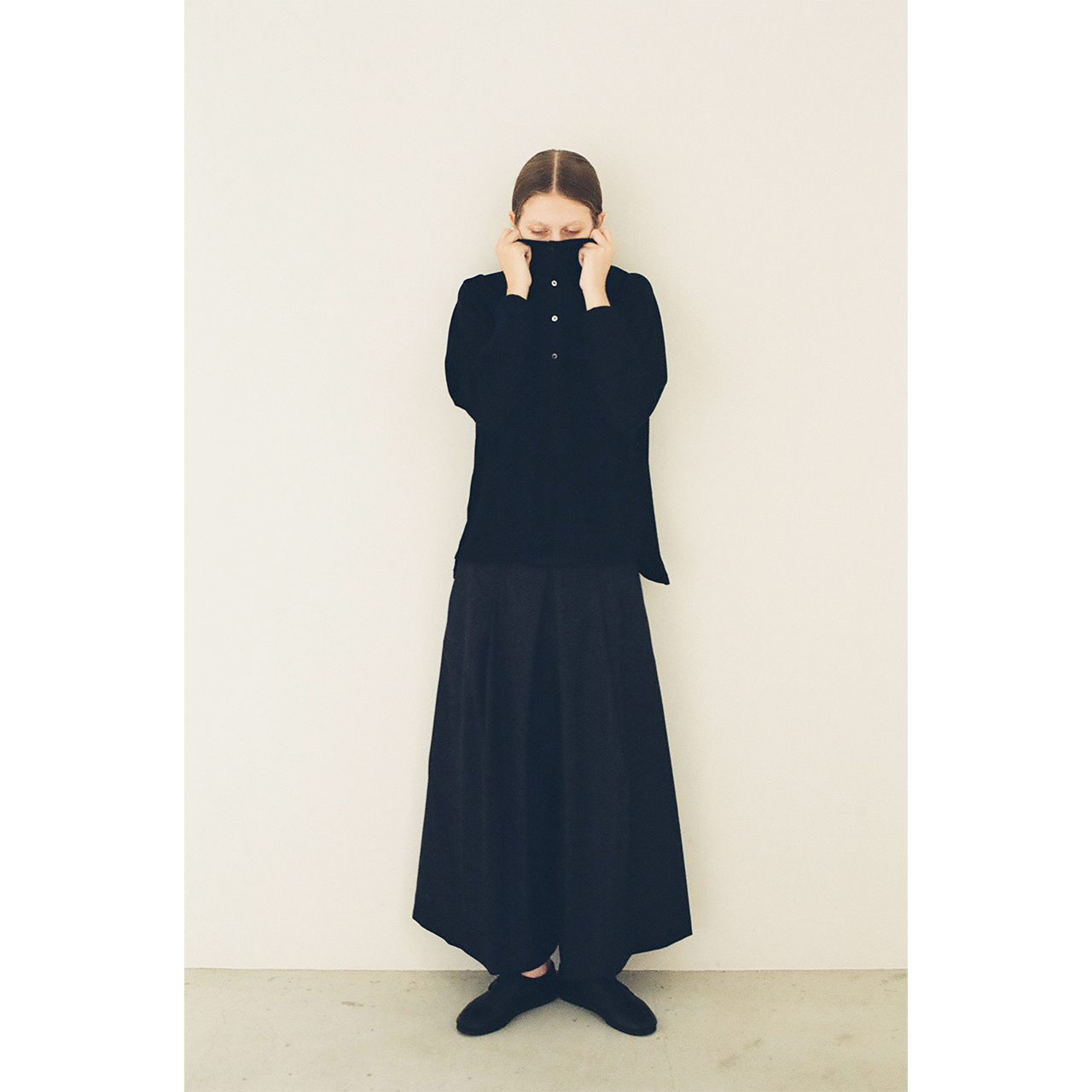 Model wearing a black blouse and long skirt in the Mochi 2026 Autumn Winter image look.